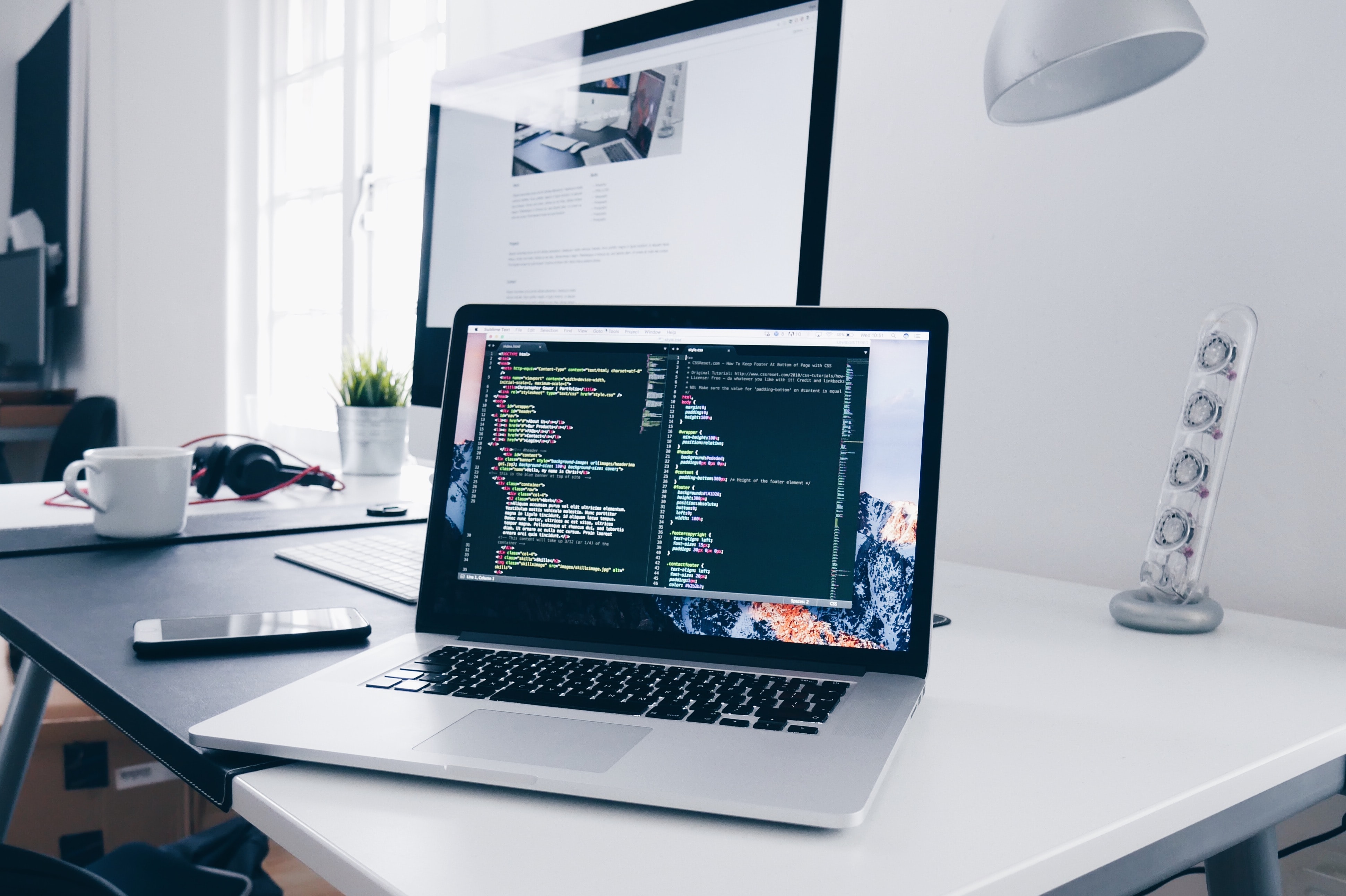 a computer on a desk with code on the screen