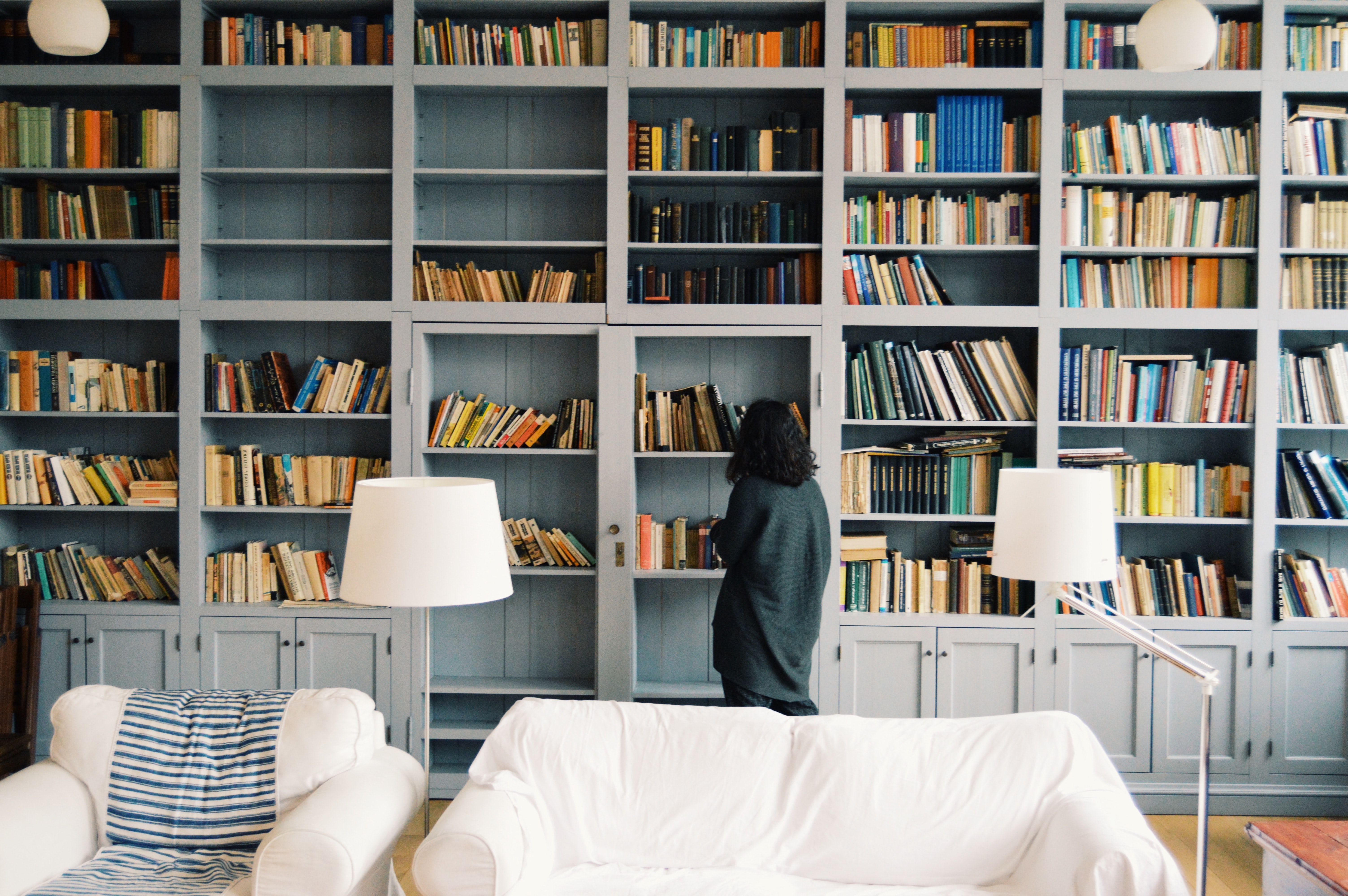 girl looking at books on a bookshelf